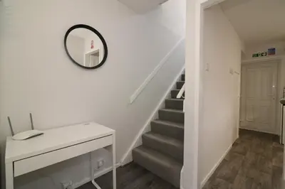 a stairwell with a mirror and a stairway with a white wall at Signature - Caldercruix House in Caldercruix
