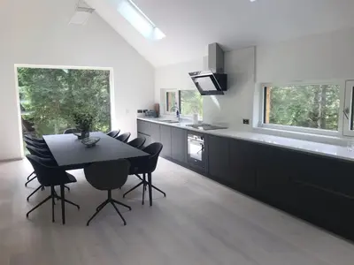 a kitchen with a black table and chairs and a counter at An Caisteal Lodge with cascading waterfall view in Crianlarich