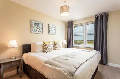 a bedroom with a large bed and a window at Old Prestwick View - Donnini Apartments in Prestwick
