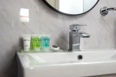 a bathroom sink with a faucet and a mirror at Stunning 5 bedroom apt, close to city centre, SEC, Hydro and motorway in Glasgow