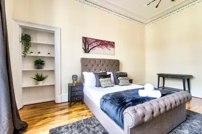 a bedroom with a large bed in a room at Stunning 5 bedroom apt, close to city centre, SEC, Hydro and motorway in Glasgow