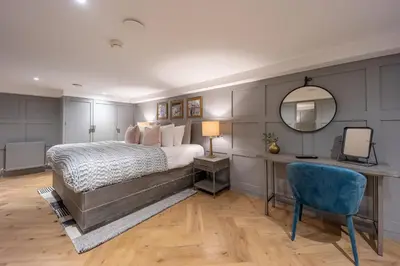 a bedroom with a bed and a mirror and a chair at No1 Apartments Edinburgh - New Town in Edinburgh