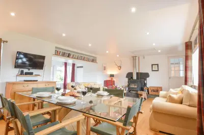 a dining room and living room with a table and chairs at Easdale Cottage in Oban