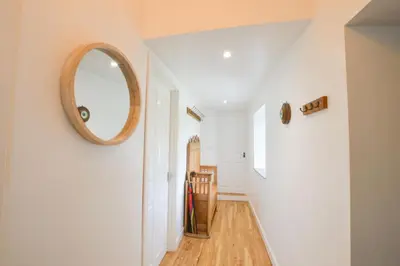 a hallway with a mirror on the wall at Easdale Cottage in Oban