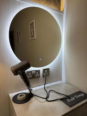 a lamp on a table in front of a mirror at Ultra Modern, Stylish Apartment Next To Princes St in Edinburgh