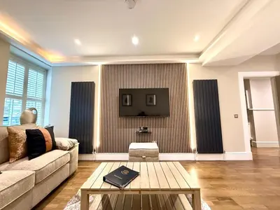 a living room with a couch and a tv on a wall at Ultra Modern, Stylish Apartment Next To Princes St in Edinburgh