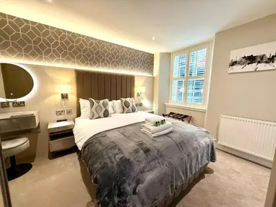 a bedroom with a large bed and a sink at Modern 3 Bedroom Apartment, West End in Edinburgh