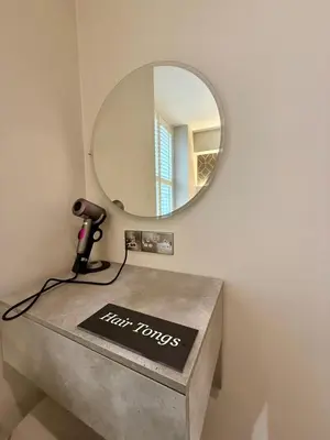 a mirror sitting on top of a counter in a bathroom at Modern 3 Bedroom Apartment, West End in Edinburgh