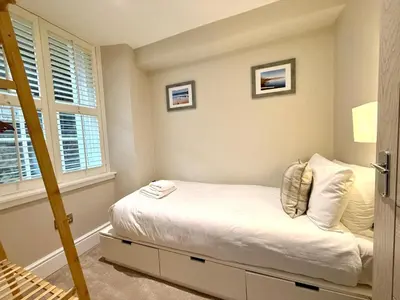 a small bedroom with a bed and a window at Modern 3 Bedroom Apartment, West End in Edinburgh