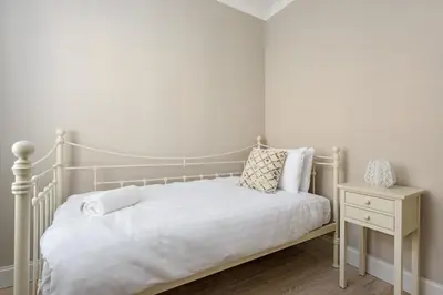 a bedroom with a white bed and a night stand at The Rose Street Retreat by Calton Living in Edinburgh