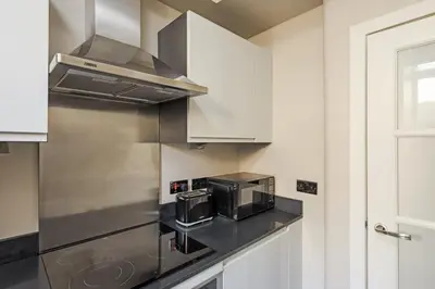 a kitchen with a microwave and a stove top oven at The Rose Street Retreat by Calton Living in Edinburgh