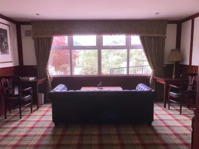 a living room with a couch and a large window at Glenorchy Lodge Hotel-Rooms Only in Dalmally