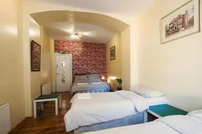 a room with three beds in it with a room with at 7 Bedroom Townhouse in Edinburgh