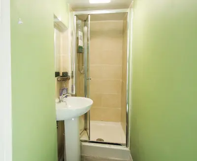 a small bathroom with a sink and a shower at 7 Bedroom Townhouse in Edinburgh