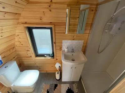 a small bathroom with a toilet and a sink at Timber Valley Pods in Galston