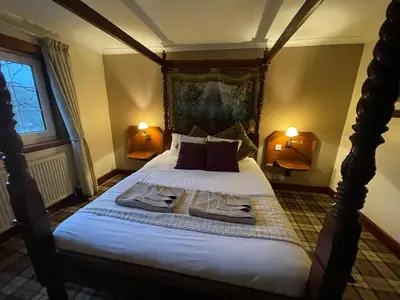 a bedroom with a bed with two robes on it at Dalgarven spa venue in Kilwinning