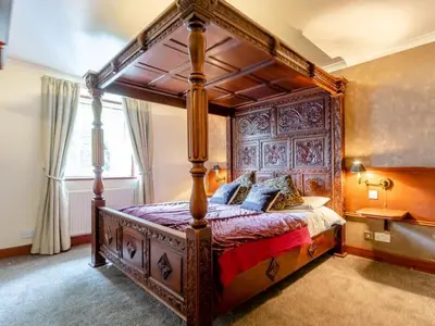 a canopy bed in a bedroom with a window at Dalgarven spa venue in Kilwinning