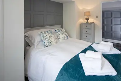 a bedroom with a white bed with towels on it at Laundry Cottage: Drumlanrig Castle in Thornhill