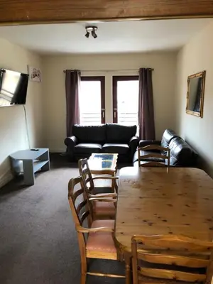 a living room with a table and chairs and a couch at Carnarvon Street City Centre Apartment in Glasgow