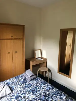 a bedroom with a bed and a desk with a chair at Carnarvon Street City Centre Apartment in Glasgow