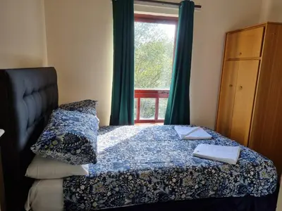 a bedroom with a bed and a window with green curtains at Carnarvon Street City Centre Apartment in Glasgow