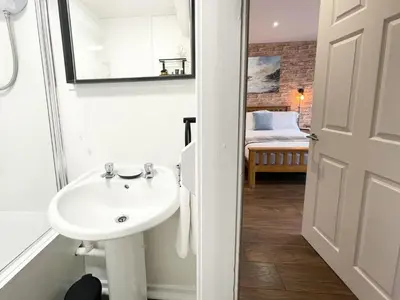 a bathroom with a sink and a mirror and a bed at Studio Hart Castle Rock Grassmarket in Edinburgh