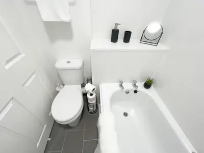 a white bathroom with a toilet and a bath tub at Studio Hart Castle Rock Grassmarket in Edinburgh