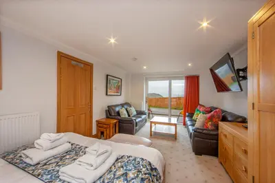 a bedroom with a bed and a living room at 5 bed house near Oban in Oban