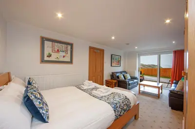 a bedroom with a bed and a living room at 5 bed house near Oban in Oban