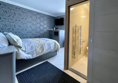 a small bedroom with a bed and a kitchen at Number 53 in Girvan
