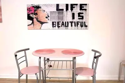 a table with two chairs and a sign that reads life is beautiful at The Cabin with optional Hot Tub Projector DEPOSIT REQUIRED FOR PROJECTOR in Bonnybridge