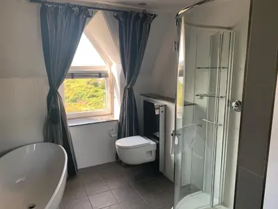 a bathroom with a shower and a toilet and a window at Corrie House in Craobh Haven