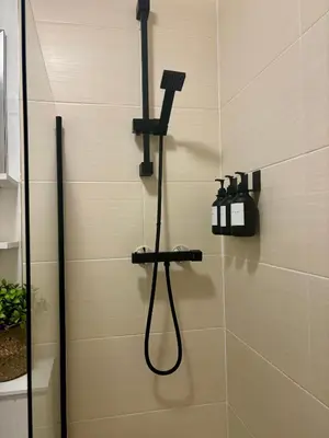 a shower with a shower head in a bathroom at Bread street, Central and spacious one bed flat in Edinburgh