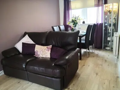 a leather couch in a living room with a table at Iona in Stirling
