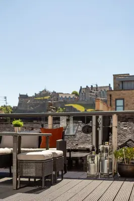a balcony with a table and chairs on a roof at The Edinburgh Rooftop Terrace in Edinburgh