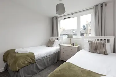 two beds in a room with a window at The Edinburgh Rooftop Terrace in Edinburgh
