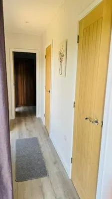 an empty hallway with two doors and a rug at Couston Lakes Resorts in Bathgate