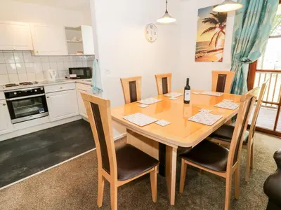 a dining room table with chairs and a bottle of wine at Brunston Castle in Girvan