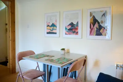 a white table with chairs and pictures on the wall at Charming Apt nr Centre - Terrace & Street Parking in Oban