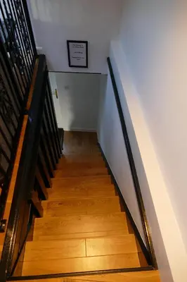 a staircase with wooden floors and a white wall at The Annexe at Loch View Farm in Crieff