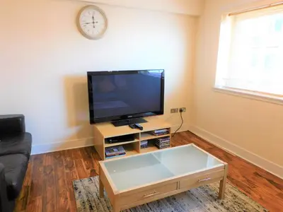 a living room with a tv and a coffee table at 2 Bedroom Apt in the Heart of the City Centre, perfect Location in Glasgow