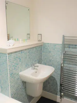 a bathroom with a sink and a mirror at 2 Bedroom Apt in the Heart of the City Centre, perfect Location in Glasgow