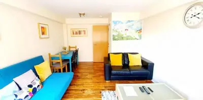 a living room with a blue couch and a table at 2 Bedroom Apt in the Heart of the City Centre, perfect Location in Glasgow