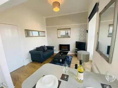 a living room with a couch and a table with wine glasses at The Sleeping Lion - Dunoon Holiday Home in Dunoon