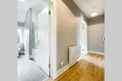 an empty hallway with a white door and wooden floors at No7 Oban Harbour in Oban