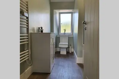 a hallway with a bathroom with a sink and a window at No7 Oban Harbour in Oban