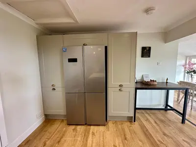 a kitchen with a stainless steel refrigerator and a table at Alton Villa, Sleeps 12, Great for Families, Undercover Hotub & Games Room in Newmilns