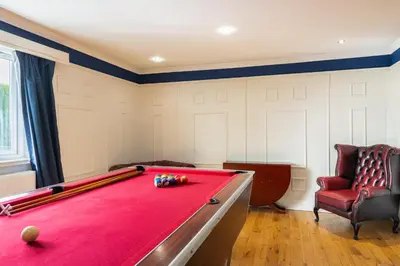 a room with a pool table and a chair at Alton Villa, Sleeps 12, Great for Families, Undercover Hotub & Games Room in Newmilns