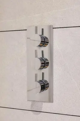 a lightswitch with three lights on a wall at Oban Bay Apartments in Oban