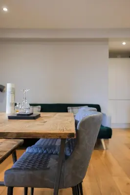 a dining room table with a wooden table and a chair at Oban Bay Apartments in Oban
